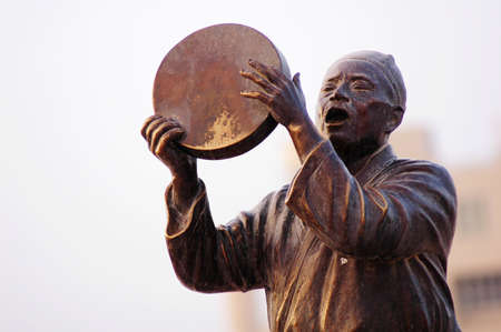 Statue of a man singing with drumの写真素材