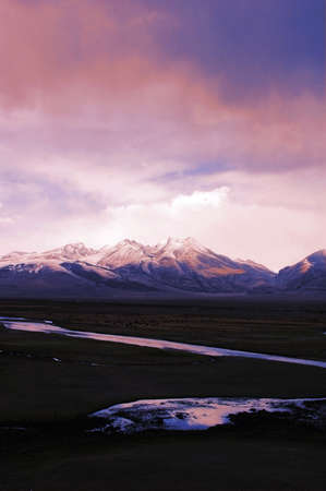 Landscape of snow mountains and stream in Tibetの写真素材