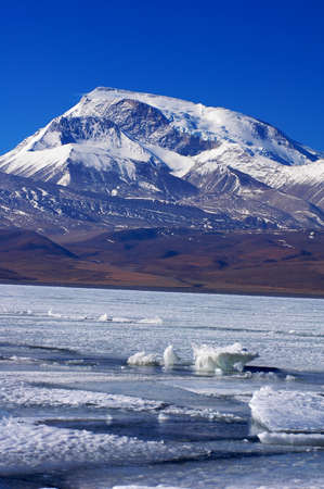 Landscape of snow mountains and blue lake in Tibetの写真素材