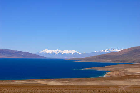 Landscape of blue lake and snow covered mountains in the highlands of Tibetの写真素材