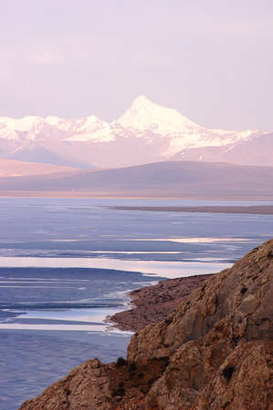 Landscape of blue lake and snow mountains at sunriseの写真素材