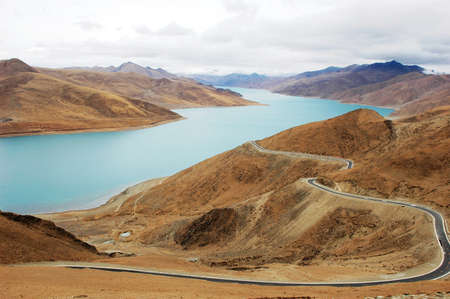 Landscape of mountains and lake with a road passing byの写真素材