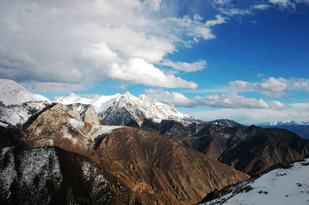 Landscape of snow-capped mountains and cloudy skies in winterの写真素材
