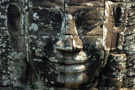 Ruins of giant smiling buddha statue at Angkor, Cambodiaの写真素材