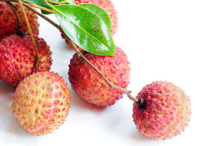 Fresh red lichi fruits with green leaves on a white backgroundの写真素材