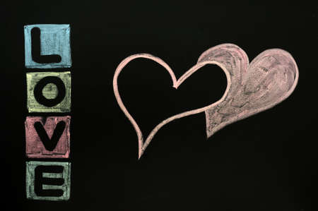 Love with two hearts drawn in colorful chalk on a chalkboard の写真素材