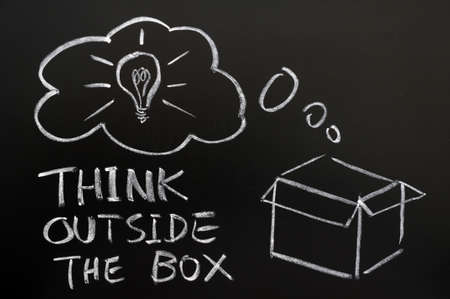 Think outside the box drawn in chalk on a blackboard Think outside the box drawn in chalk on a blackboard