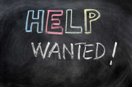 Help wanted message written in chalk on a blackboard