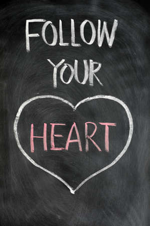 Follow your heart drawn in chalk on a blackboardの写真素材