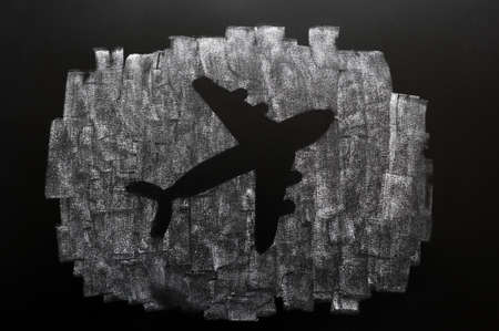 Shape of a plane drawn with white chalk on a blackboardの写真素材