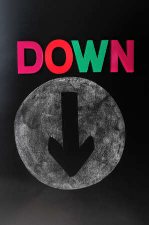 Down arrow drawn on a blackboardの写真素材
