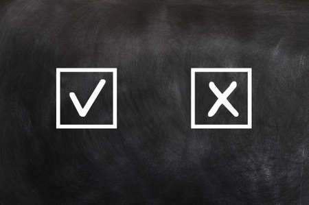 Check boxes with tick and cross on a blackboardの写真素材