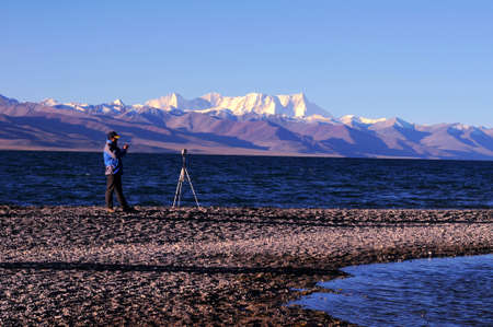 Landscape of mountains and lakes in the highlands of Tibet,with a photographer's silhouette