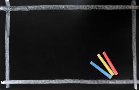 Blackboard background with a chalk frame and colorful chalkの写真素材