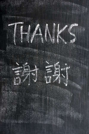 Thanks - word written on a blackboard with Chinese version charactersの写真素材