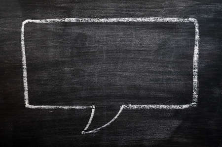 Blank speech bubble drawn with chalk on a smudged blackboard background for text writing and design