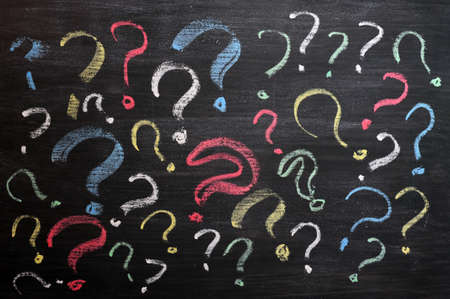 Question marks on chalkboard. Decision, confusion, FAQ or other concept. Hand writing with chalk on school black board. の写真素材