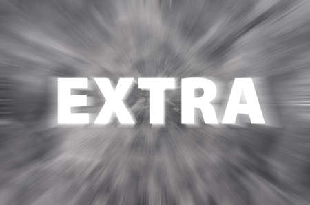 Chalk drawing of  Extra  word written on a blurred chalkboard with motion raysの写真素材