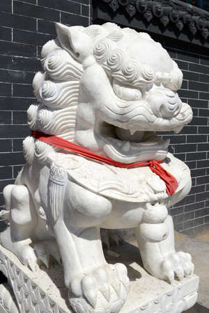 Chinese Imperial Lion Statue with a red scarfの写真素材