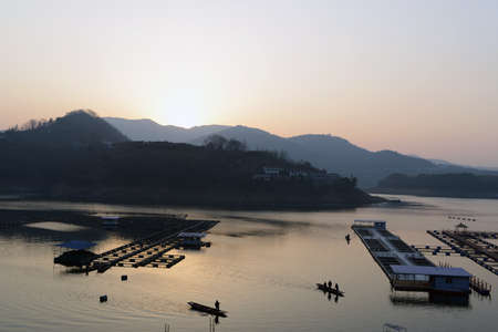 Landscape of sunset on a lake with boatsの写真素材