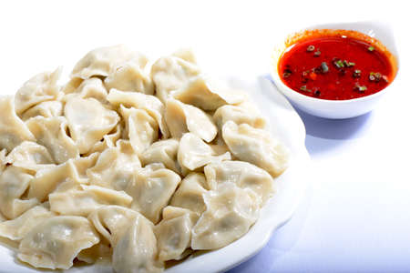 Chinese Food:  boiled dumplings with sauce on a white backgroundの写真素材