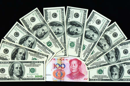 Pile of USD and RMB bank notes on a black backgroundの写真素材