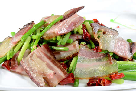 Chinese Food: Fried bacon with vegetable in a white plateの写真素材