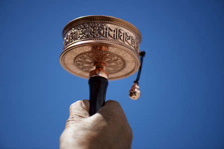 Prayer Wheel against blurred blue sky in Tibetの写真素材