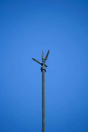a metal rod or wire fixed to an exposed part of a building or other tall structure to divert lightning harmlessly into the ground.の写真素材