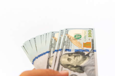 Close up of stack hundred new US dollar on hand Money American isolated on white background.