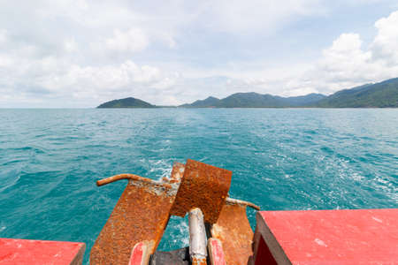 Stern view boat floats and island sea view on bright blue beach from tropical. Koh Chang in THAILAND.の写真素材