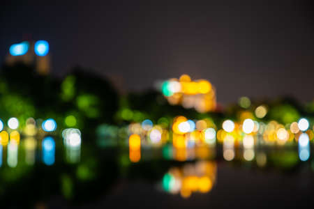 Abstract bokeh of Green, yellow, red, blue on street lights black background. Night life and reflect on the water.の写真素材