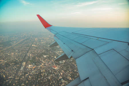 Beautiful sunset, sky on the top view  city, airplane flying view from inside window aircraft of Traveling.の写真素材
