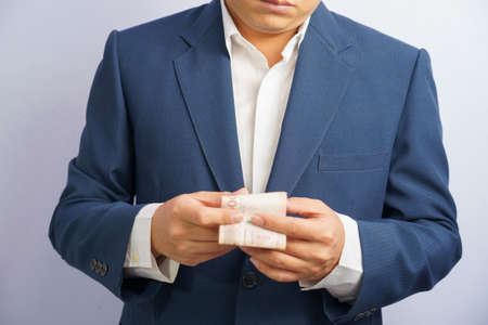 Money in thailand hold on hand business man grabbing wearing a blue suit, Filed and put and give to...