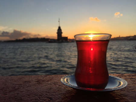 a glass of turkish tea against Tower at sunset in Istanbulの写真素材
