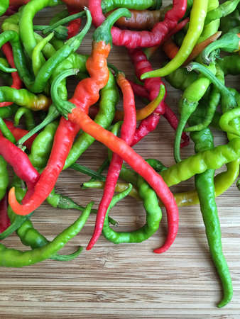 colorful fresh hot peppers on a wooden surface with copy space