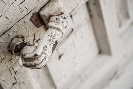 Hand shaped knocker on an old wooden doorの写真素材