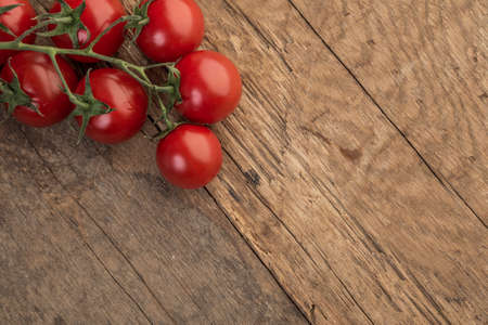 Fresh ripe cherry tomatoes on wooden table with copy spaceの写真素材