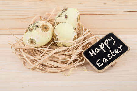 Easter eggs decorated with daisy flowers on wooden surface