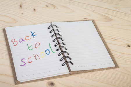 back to school template with a notebook on wooden deskの写真素材
