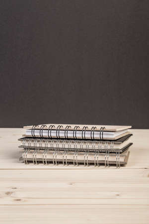 some notebooks on a wooden table against blackの写真素材