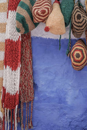 Colorful knit hats and scarfs hanged on wall with copy spaceの写真素材
