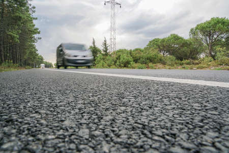 A vehicle on road surrounded by treesのeditorial素材