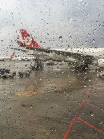 Turkish Airlines plane waiting for boarding at Turkey's largest and busiest airport that is Istanbul Ataturk Airport in Istanbul, Turkey in a rainy day.のeditorial素材