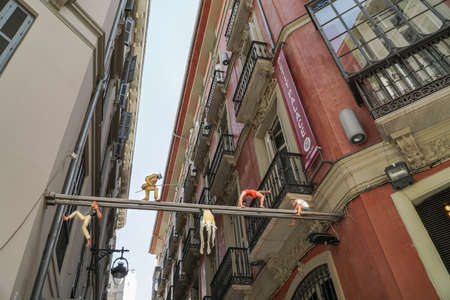 Some figurines between buildings near Larios Street in Malaga, Spain.のeditorial素材