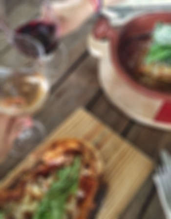 Blurred background with hands toasting their wine glasses in an Italian restaurantの写真素材