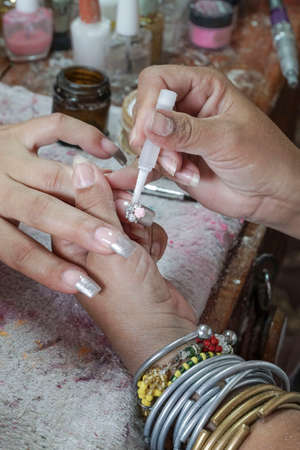 Manicure process in a beauty salon showing making of artificial nails for a womanの写真素材