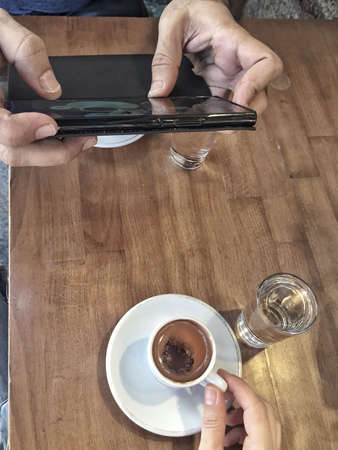taking photo of Turkish coffee cups on table, with smartphoneの写真素材