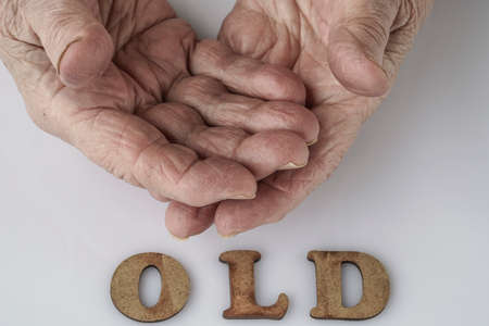 Closeup wrinkled hands of a senior person on whiteの写真素材