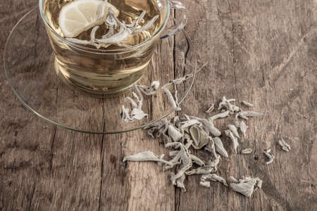 A cup of natural sage tea on wooden tableの写真素材